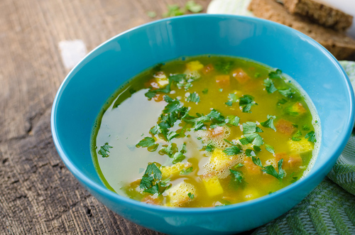 Imperial Soup - Italian Soup / NelliSyr Zuppa Imperiale - Italian soup with eggs and Parmesan cheese, dish of Emilia Romagna. Imperial soup on wooden table. Omelet in chicken broth with parsley in a bowl. Italian cuisine concept.